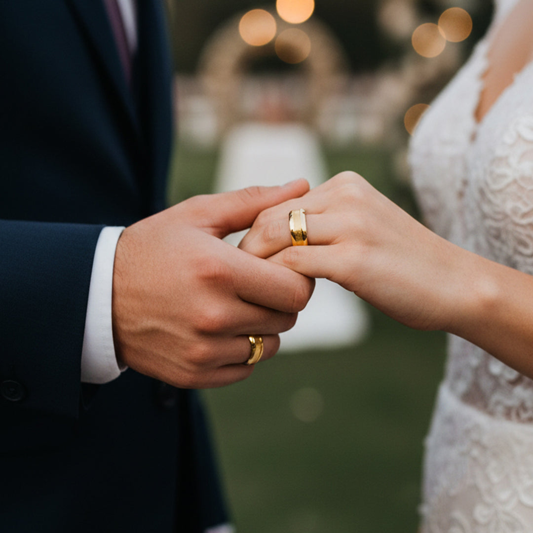 Manos de una pareja usando unas argollas de matrimonio en oro amarillo de 18 quilates de Joyería Caracas. 