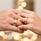 Manos de una pareja usando unas argollas en oro amarillo y blanco de 18 quilates con cristales de Joyería Caracas.
