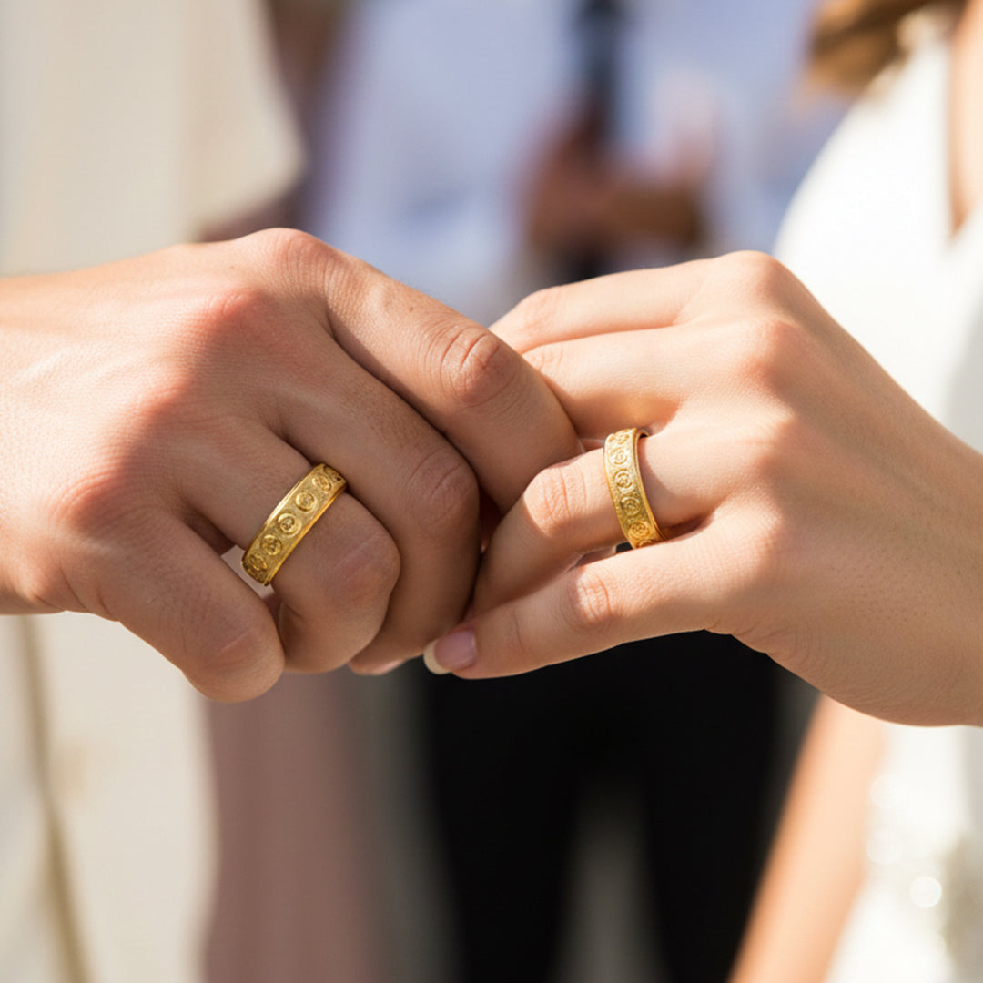 Manos de una pareja usando unas argollas en oro amarillo de 18 quilates de Joyería Caracas. 