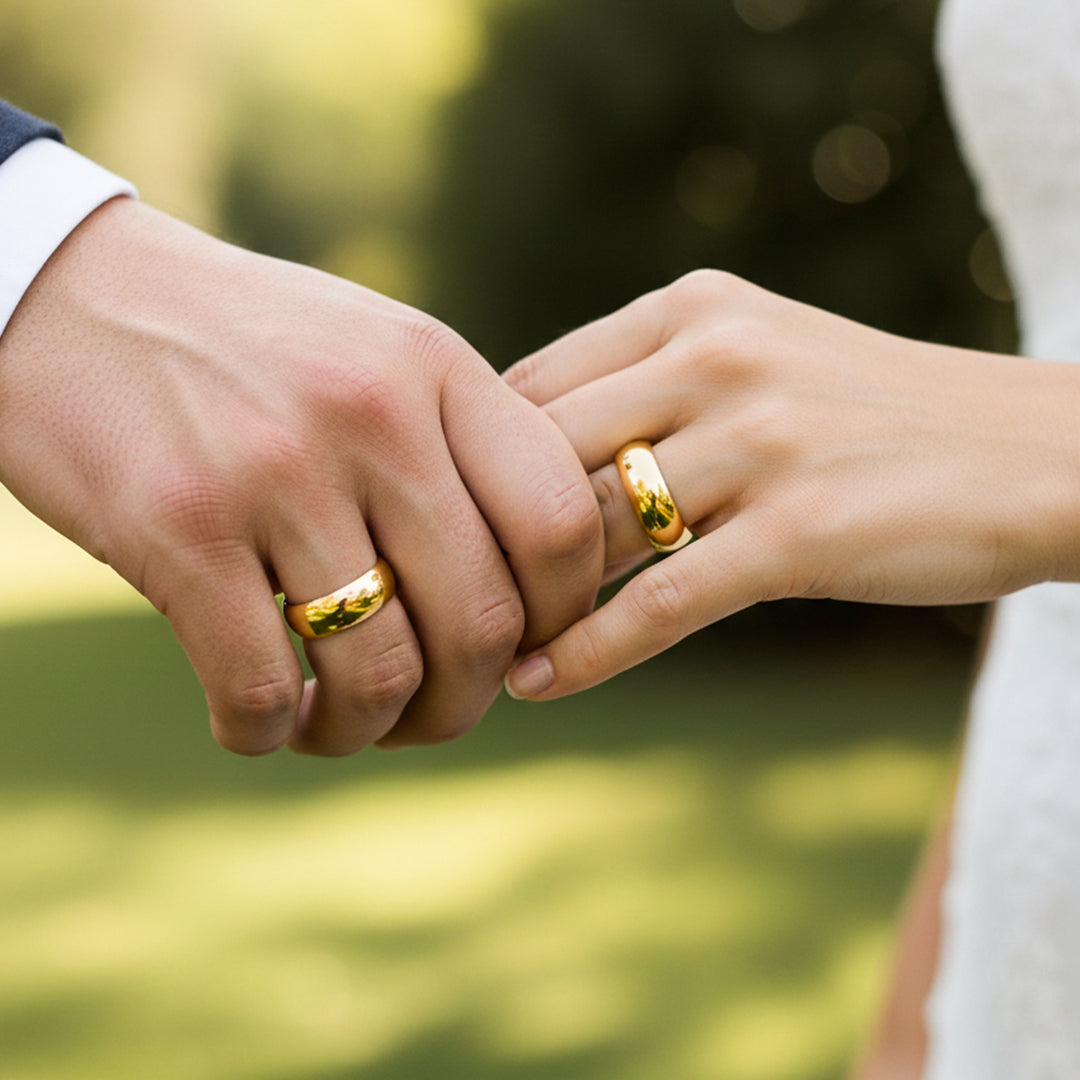 Manos de una pareja usando unas argollas en oro amarillo de 18 quilates de Joyería Caracas.