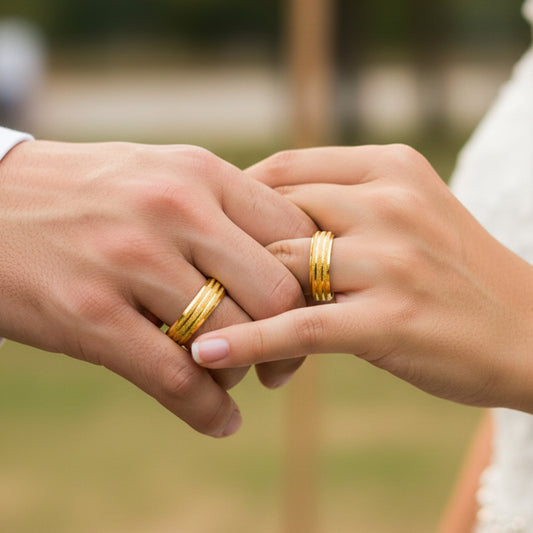Manos de una pareja usando unas argollas en oro amarillo de 18 quilates de Joyería Caracas. 