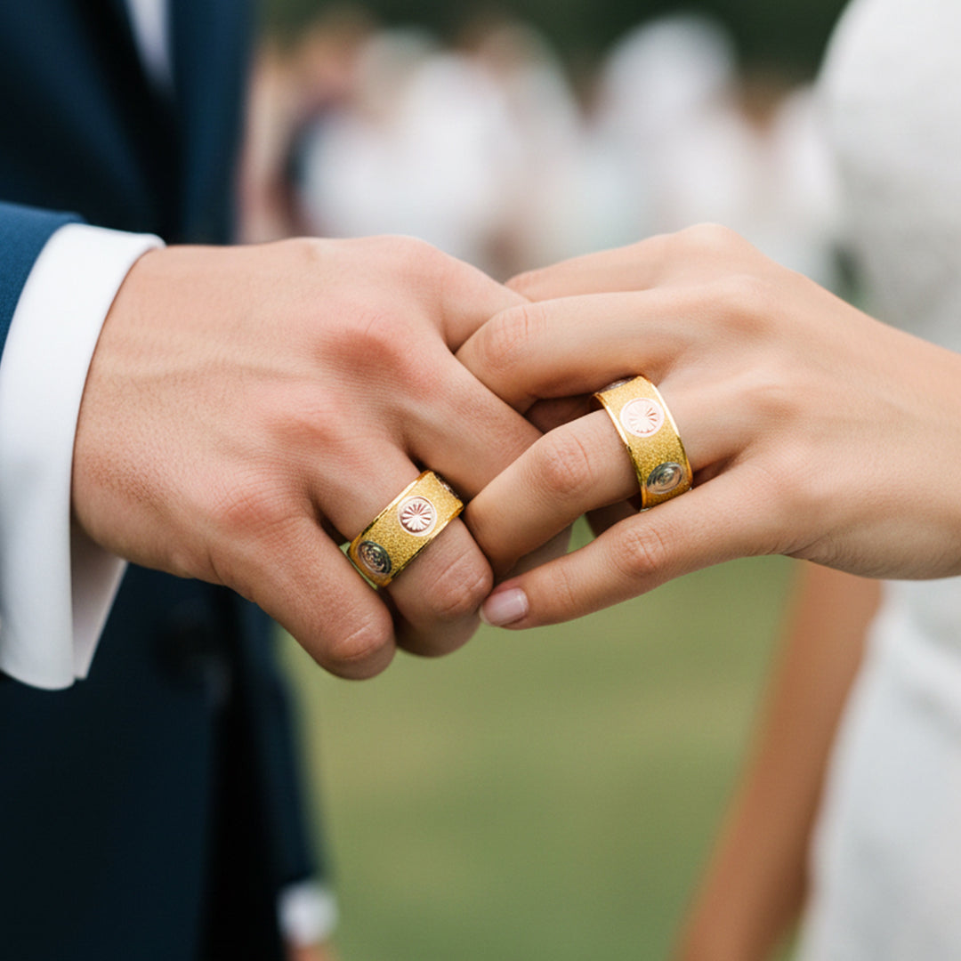 Manos de una pareja usando unas argollas de matrimonio en oro amarillo, blanco y rosa de 18 quilates de Joyería Caracas. 