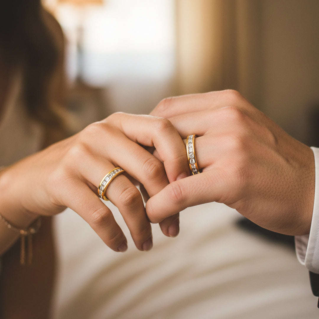 Manos de una pareja usando unas argollas de matrimonio en oro amarillo sin fin de 18 quilates con cristales de Joyería Caracas. 