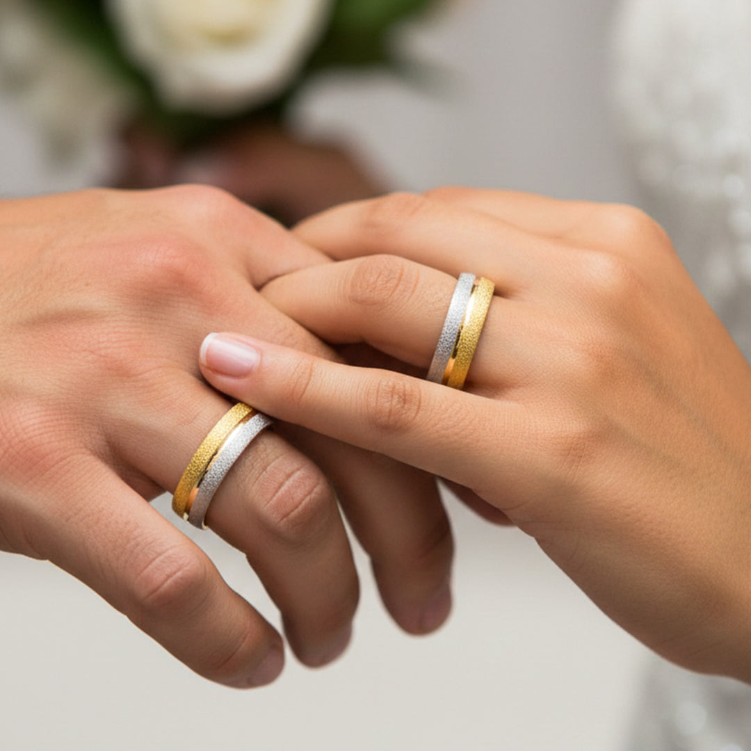 Manos de una pareja usando unas argollas en oro amarillo de 18 quilates de Joyería Caracas. 