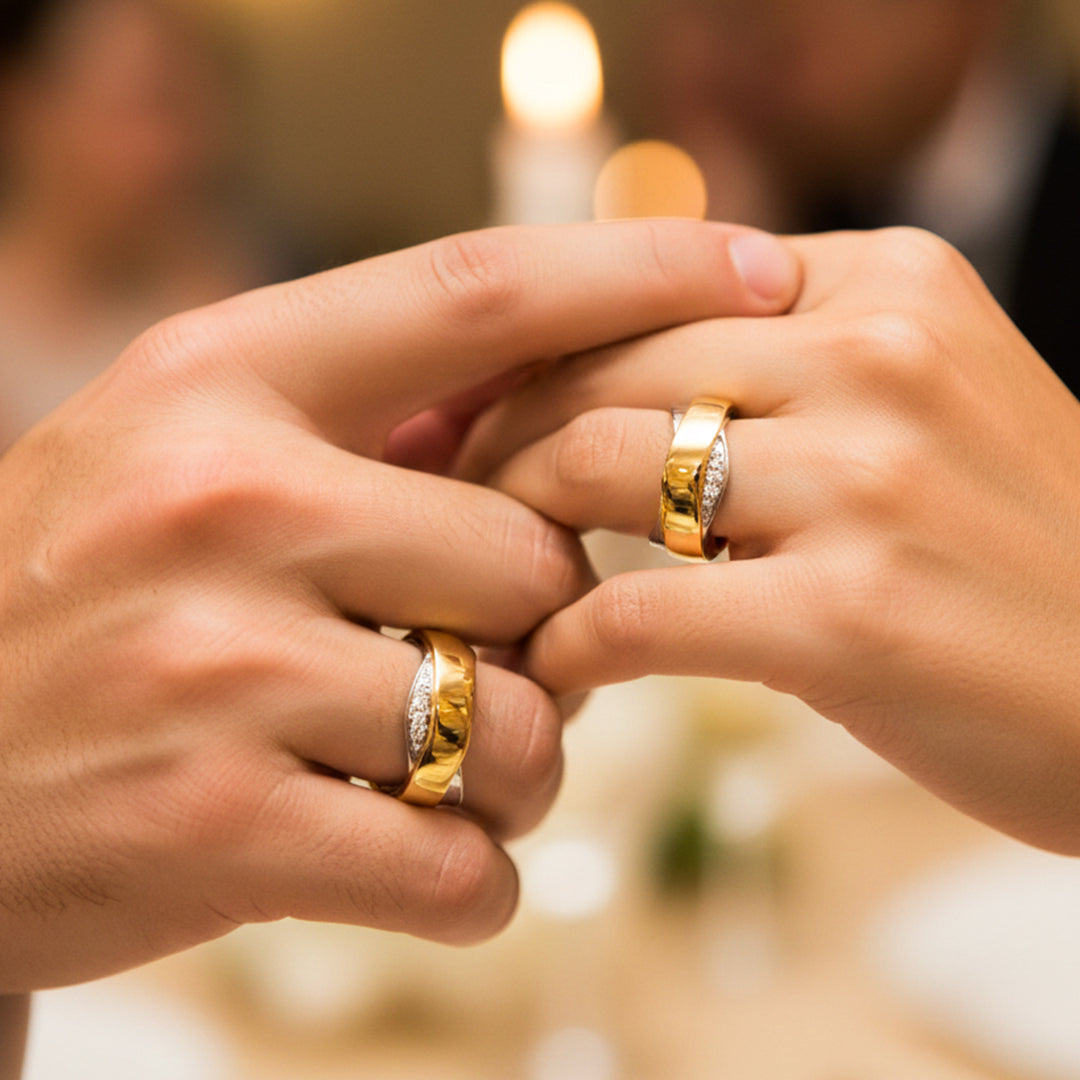 Manos de una pareja usando unas argollas de matrimonio en oro amarillo y blanco de 18 quilates con cristales de Joyería Caracas. 