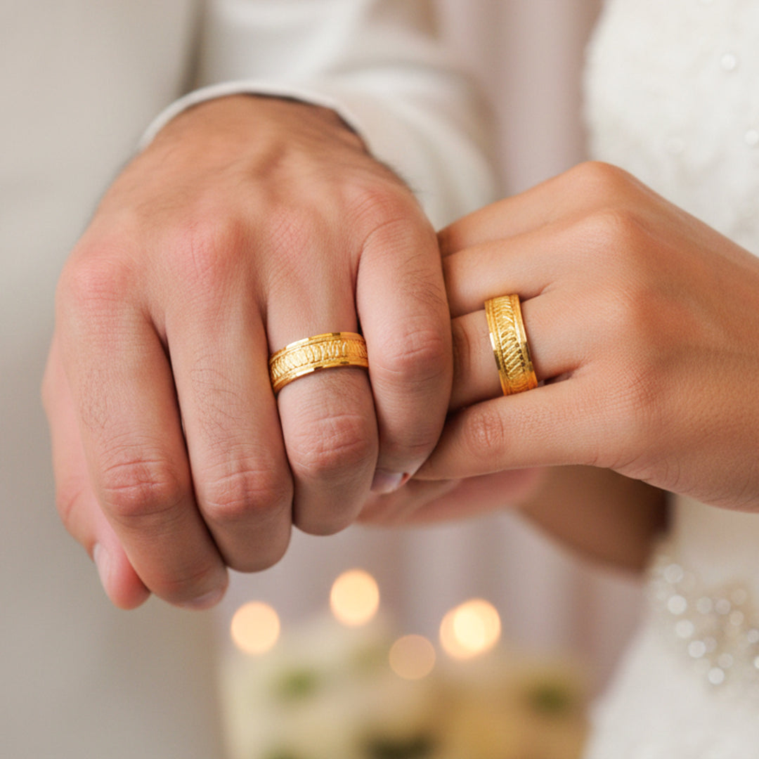 Manos de una pareja usando unas argollas en oro amarillo de 18 quilates de Joyería Caracas. 