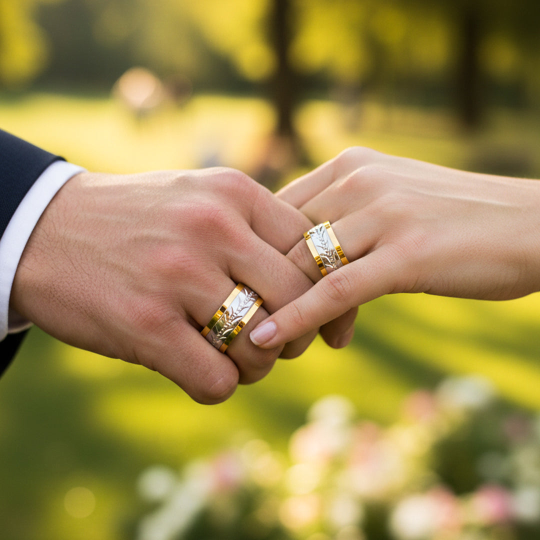 Manos de una pareja usando unas argollas de matrimonio en oro amarillo y blanco de 18 quilates de Joyería Caracas. 