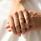 Manos de una pareja usando unas argollas en oro amarillo de 18 quilates de Joyería Caracas. 