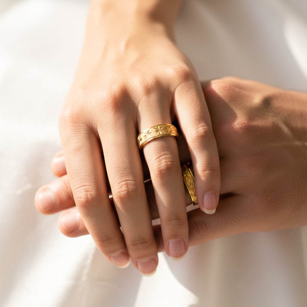Manos de una pareja usando unas argollas en oro amarillo de 18 quilates de Joyería Caracas. 
