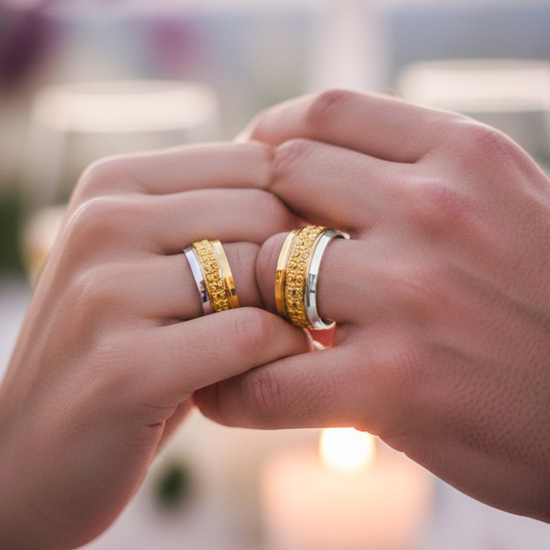Manos de una pareja usando unas argollas en oro amarillo y blanco de 18 quilates de Joyería Caracas.