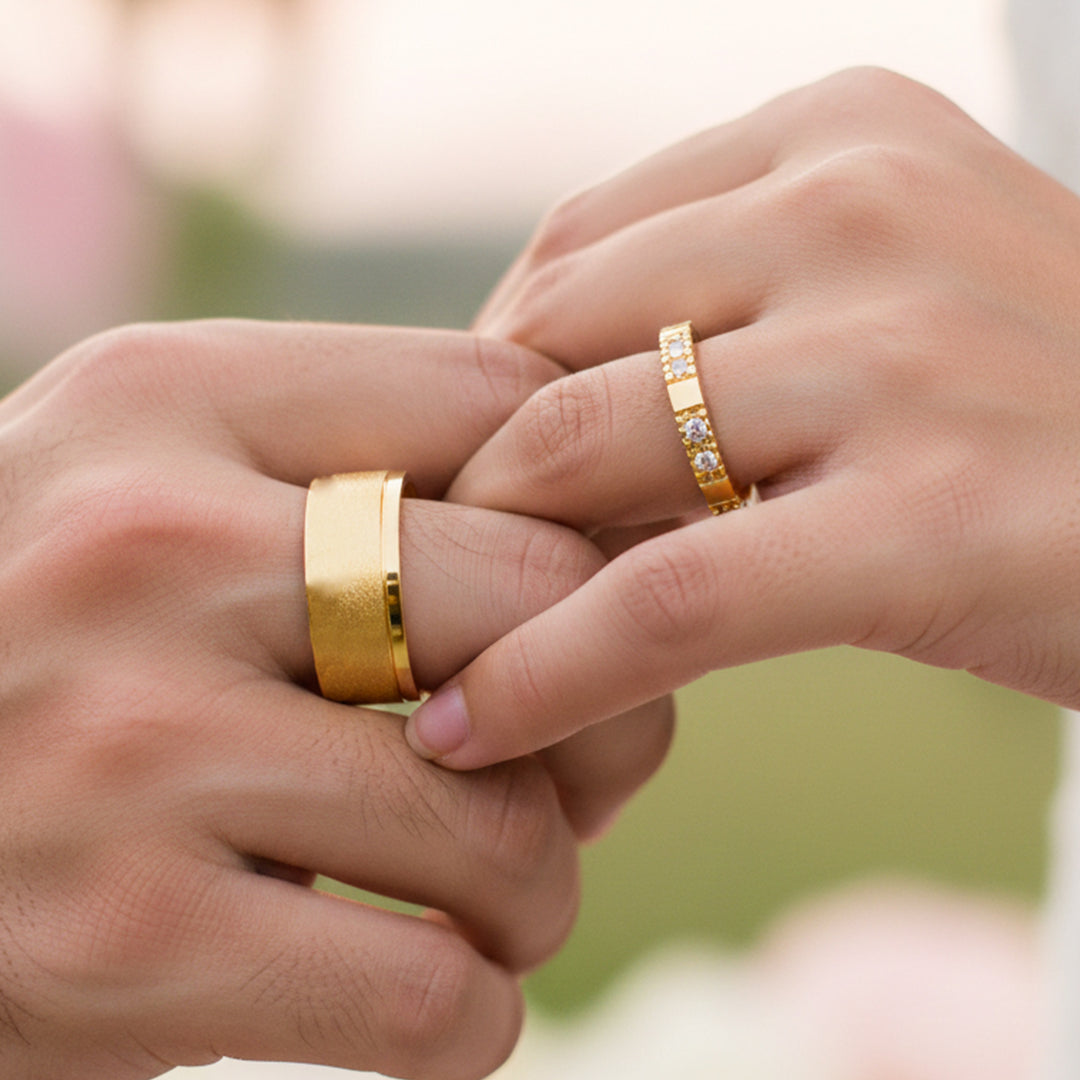 Manos de una pareja usando unas argollas en oro amarillo de 18 quilates con cristales de Joyería Caracas.