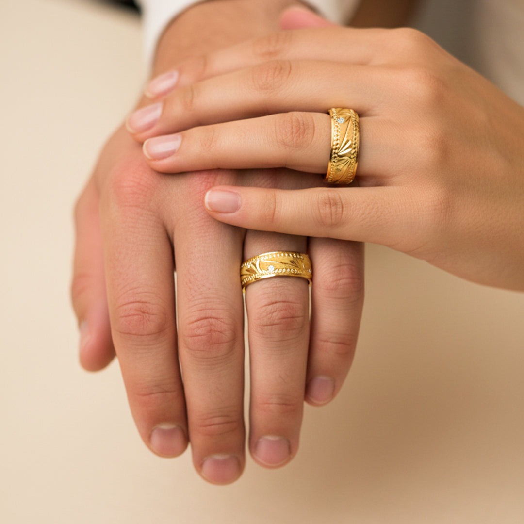 Manos de una pareja usando unas argollas en oro amarillo de 18 quilates de Joyería Caracas. 