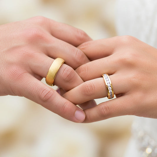 Manos de una pareja usando unas argollas de matrimonio en oro amarillo de 18 quilates con cristales de Joyería Caracas. 