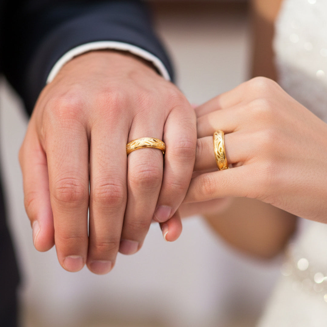 Manos de una pareja usando unas argollas en oro amarillo de 18 quilates de Joyería Caracas. 