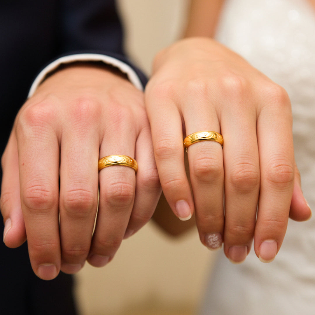 Manos de una pareja usando unas argollas en oro amarillo de 18 quilates de Joyería Caracas. 