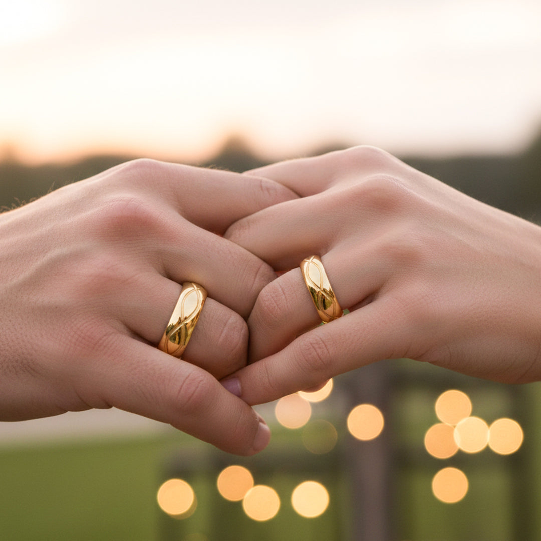 Manos de una pareja usando unas argollas en oro amarillo de 18 quilates de Joyería Caracas.