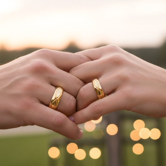 Manos de una pareja usando unas argollas en oro amarillo de 18 quilates de Joyería Caracas.
