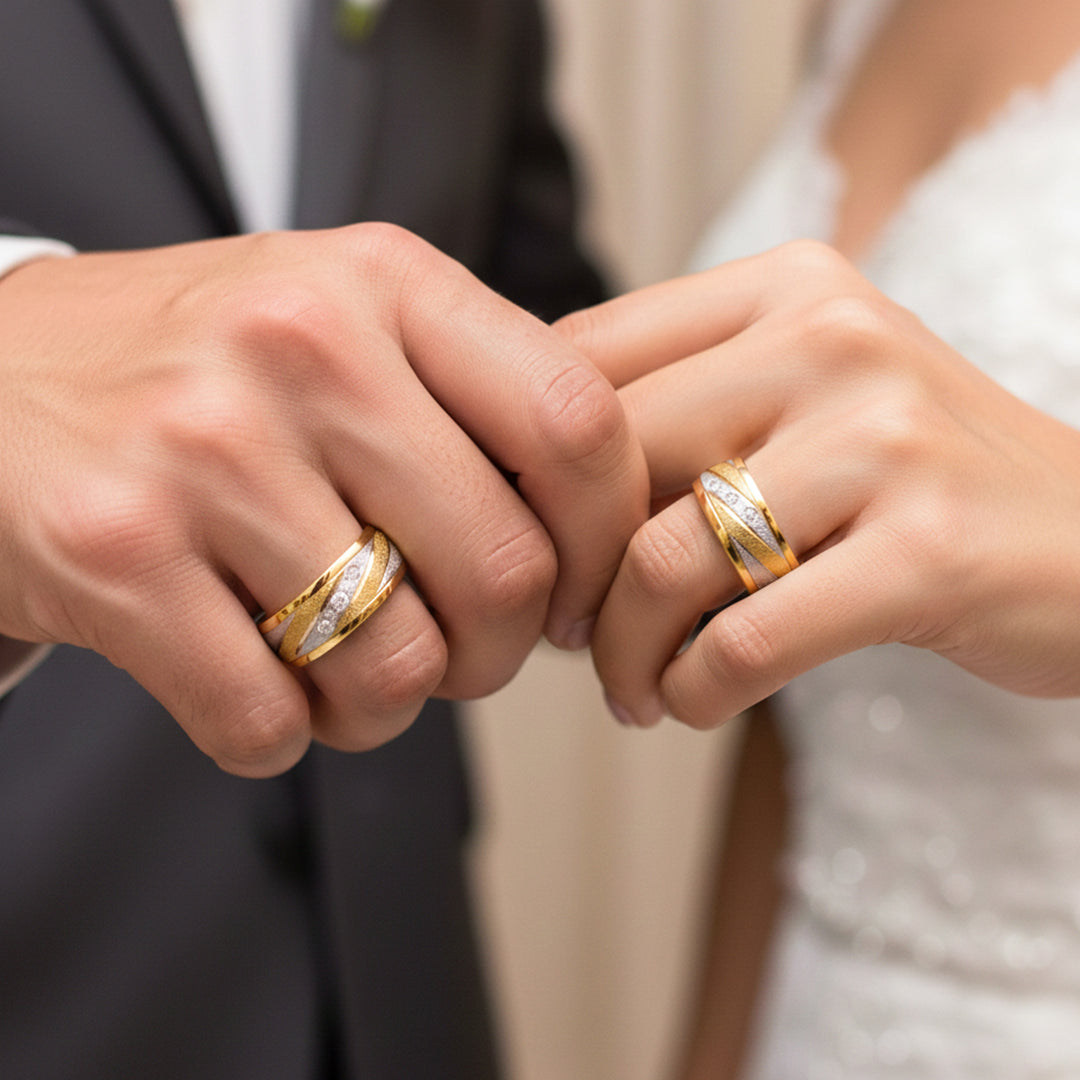 Manos de una pareja usando unas argollas de matrimonio en oro amarillo y blanco de 18 quilates con cristales de Joyería Caracas. 
