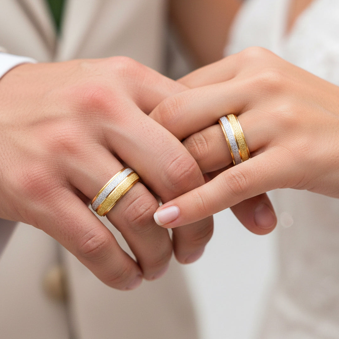Manos de una pareja usando unas argollas en oro amarillo y blanco de 18 quilates de Joyería Caracas.