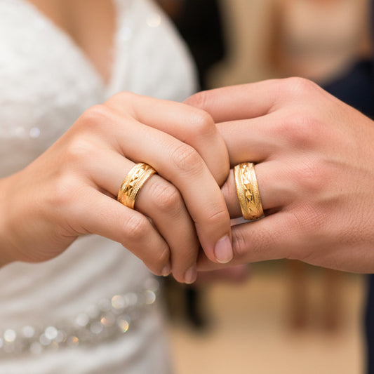 Manos de una pareja usando unas argollas en oro amarillo de 18 quilates de Joyería Caracas.