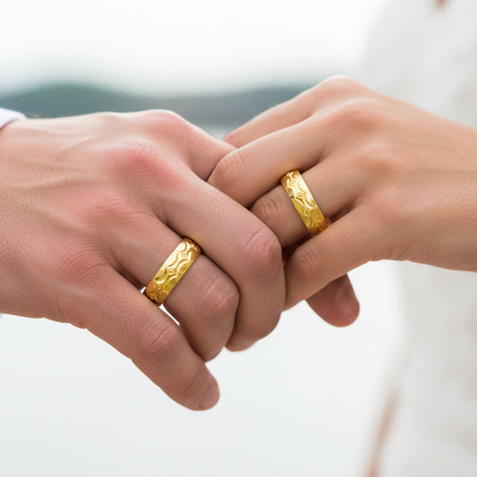 Manos de una pareja usando unas argollas en oro amarillo de 18 quilates de Joyería Caracas. 