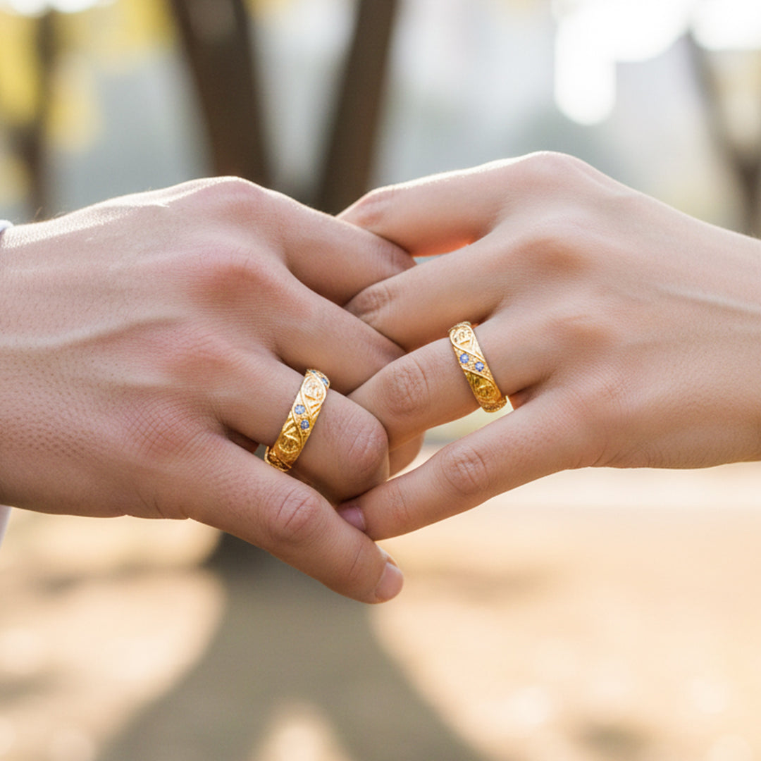 Manos de una pareja usando unas argollas de matrimonio en oro amarillo de 18 quilates con cristales de Joyería Caracas. 