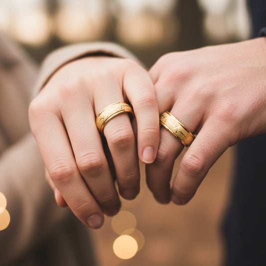 Manos de una pareja usando unas argollas en oro amarillo de 18 quilates de Joyería Caracas.