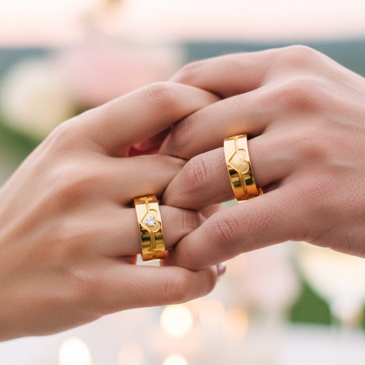 Manos de una pareja usando unas argollas en oro amarillo de 18 quilates con forma de latidos de corazón en 3D de Joyería Caracas.