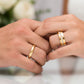Manos de una pareja usando unas argollas de matrimonio en oro amarillo de 18 quilates con cristales de Joyería Caracas. 