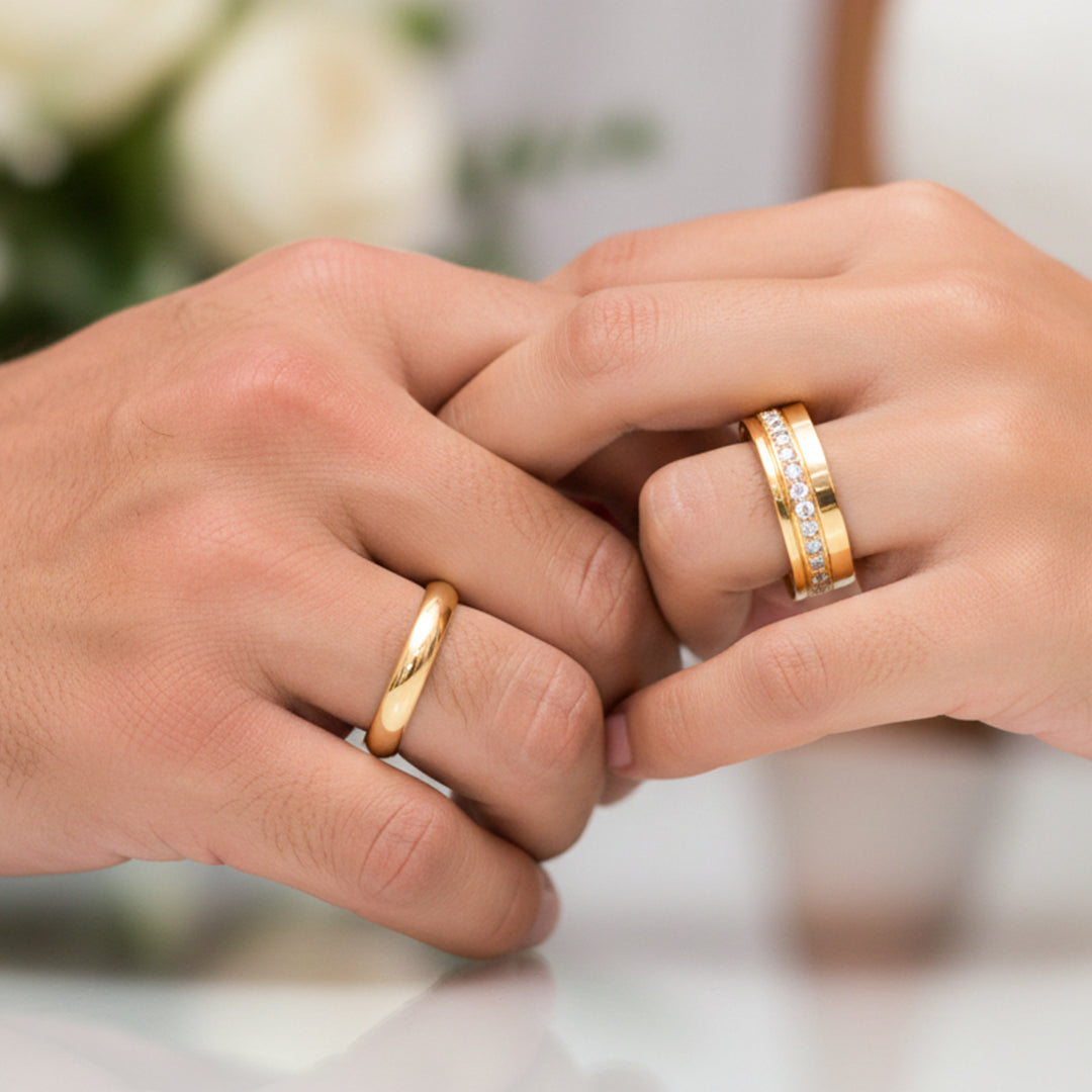 Manos de una pareja usando unas argollas de matrimonio en oro amarillo de 18 quilates con cristales de Joyería Caracas. 