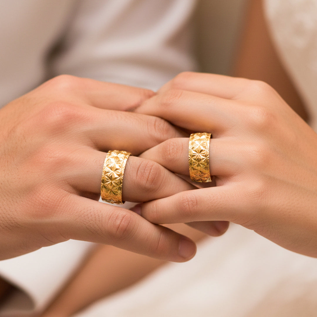 Manos de una pareja usando unas argollas en oro amarillo de 18 quilates de Joyería Caracas.