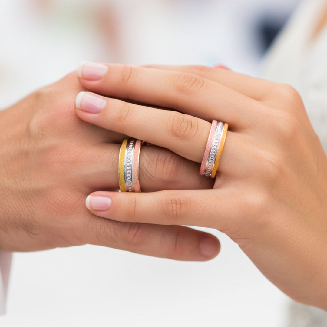 Manos de una pareja usando unas argollas en oro amarillo de 18 quilates de Joyería Caracas. 
