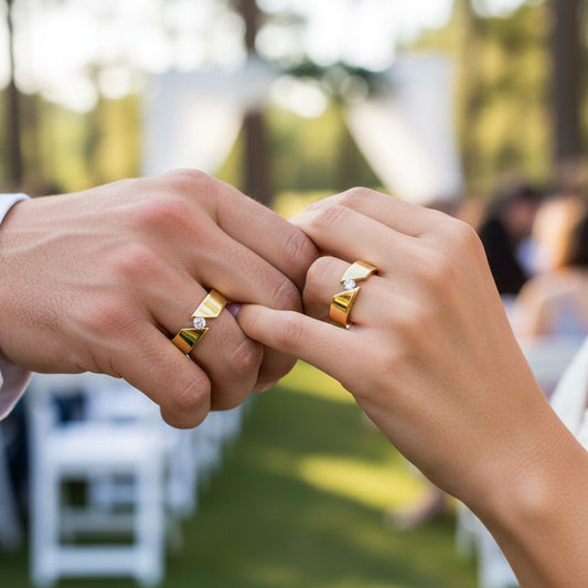 Manos de una pareja usando unas argollas en oro amarillo de 18 quilates y cristales de Joyería Caracas.
