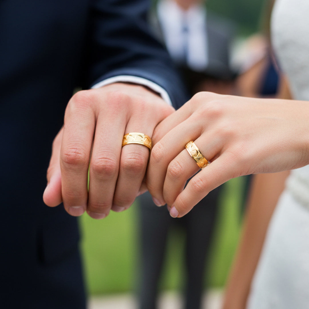 Manos de una pareja usando unas argollas en oro amarillo de 18 quilates de Joyería Caracas. 