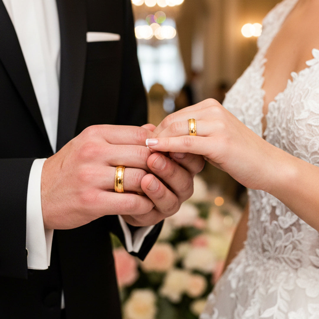 Manos de una pareja usando unas argollas de matrimonio en oro amarillo de 18 quilates de Joyería Caracas. 