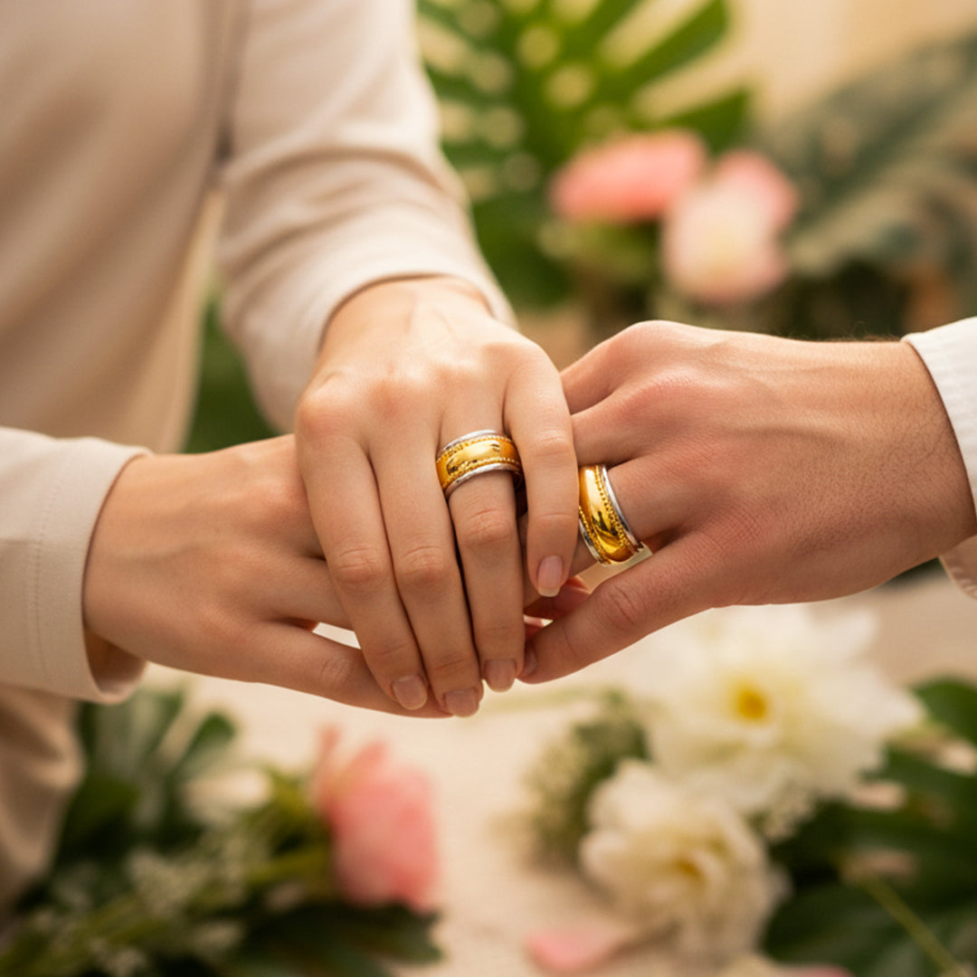 Manos de una pareja usando unas argollas en oro amarillo y blanco de 18 quilates de Joyería Caracas.