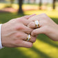 Manos de una pareja usando unas argollas de matrimonio en oro amarillo y blanco de 18 quilates con cristales de Joyería Caracas. 