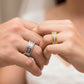 Manos de una pareja usando unas argollas de matrimonio con diseño único en oro amarillo y blanco de 18 quilates y con cristales de Joyería Caracas.