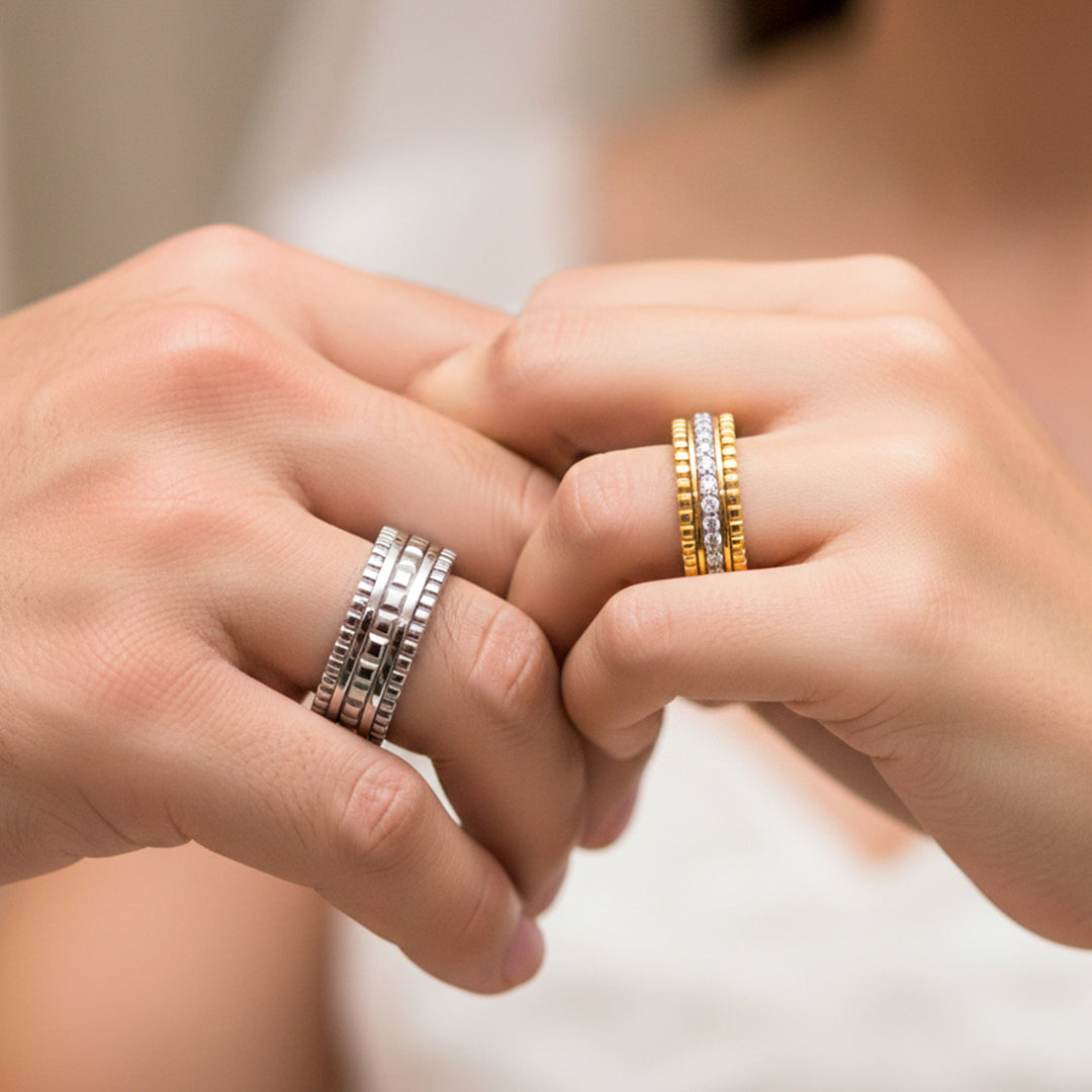 Manos de una pareja usando unas argollas de matrimonio con diseño único en oro amarillo y blanco de 18 quilates y con cristales de Joyería Caracas.