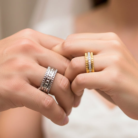 Manos de una pareja usando unas argollas de matrimonio con diseño único en oro amarillo y blanco de 18 quilates y con cristales de Joyería Caracas.