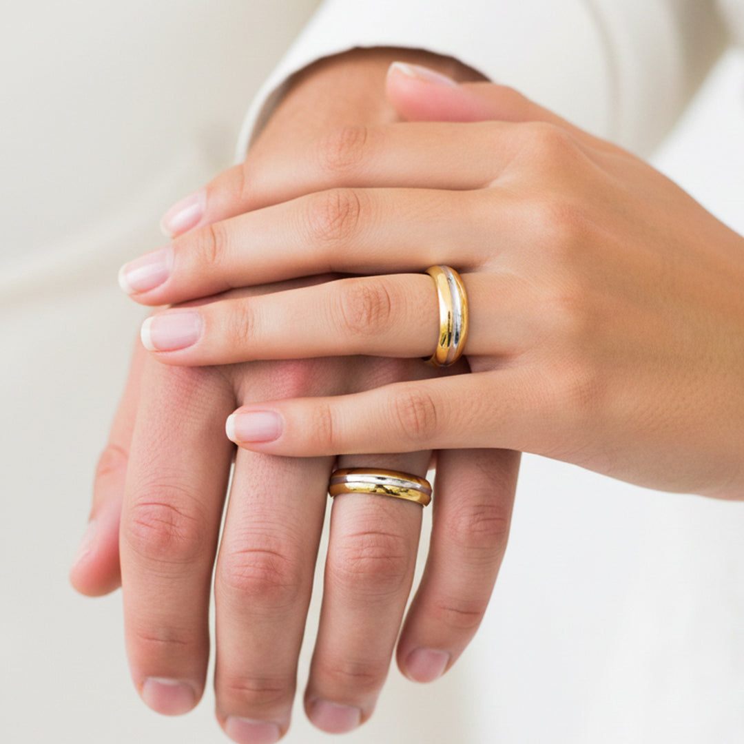 Manos de una pareja usando unas argollas en oro amarillo de 18 quilates de Joyería Caracas. 