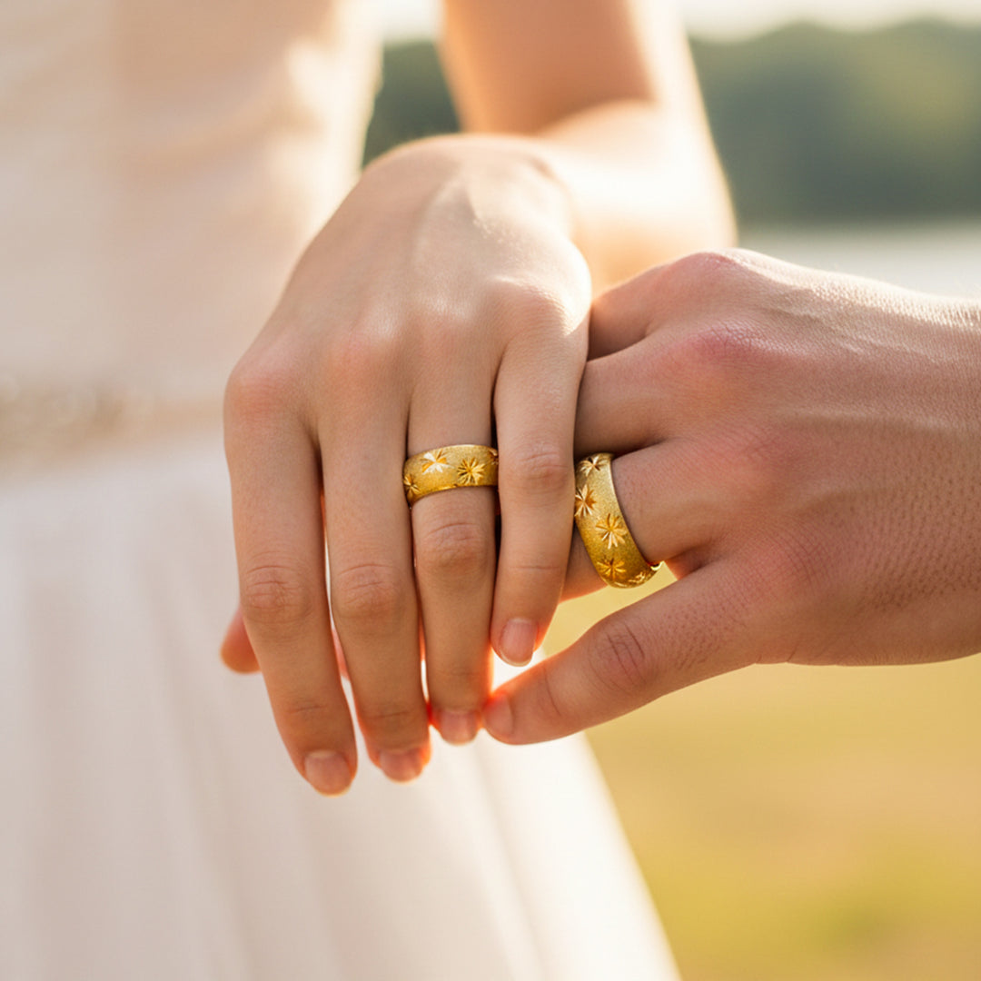 Manos de una pareja usando unas argollas en oro amarillo de 18 quilates de Joyería Caracas. 