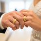 Manos de una pareja usando unas argollas en oro amarillo de 18 quilates de Joyería Caracas. 