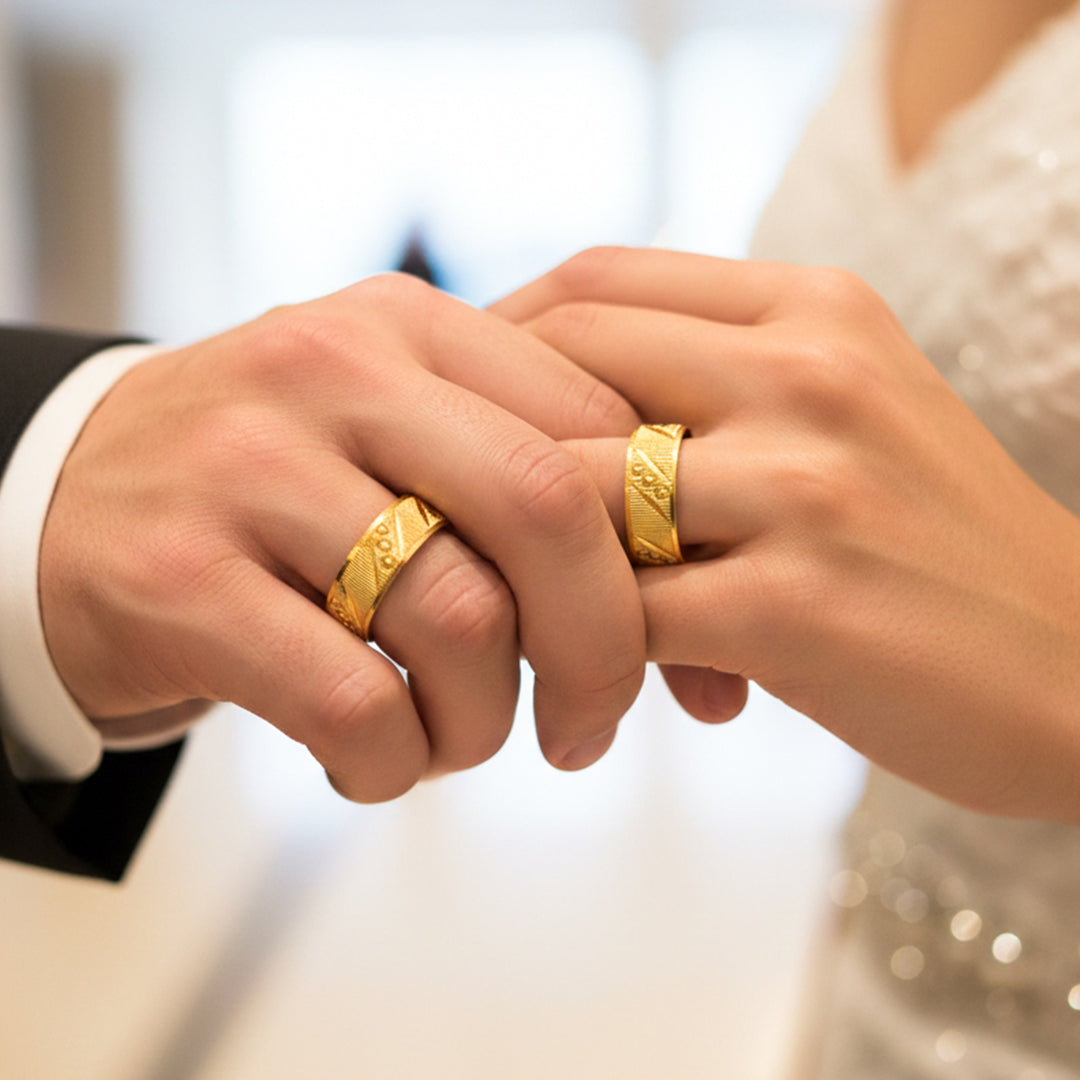 Manos de una pareja usando unas argollas en oro amarillo de 18 quilates de Joyería Caracas. 