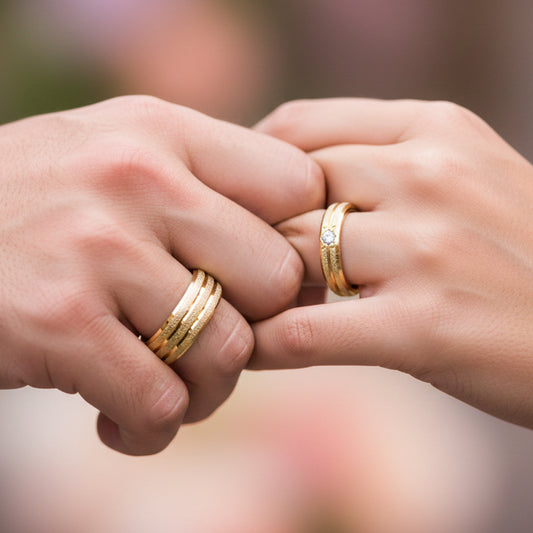 Manos de una pareja usando unas argollas en oro amarillo de 18 quilates con cristal de Joyería Caracas.