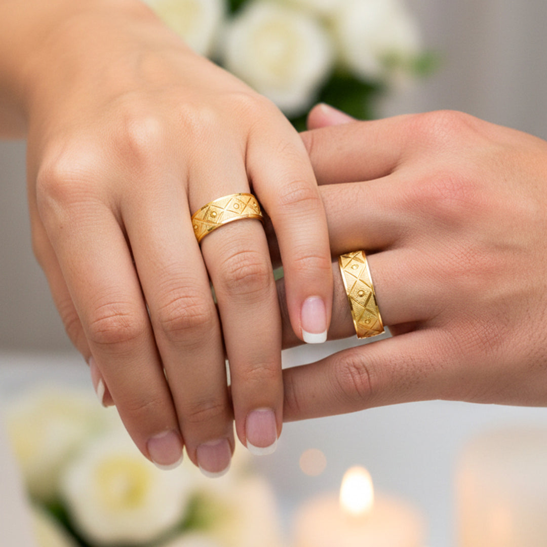 Manos de una pareja usando unas argollas de matrimonio en oro amarillo de 18 quilates de Joyería Caracas.