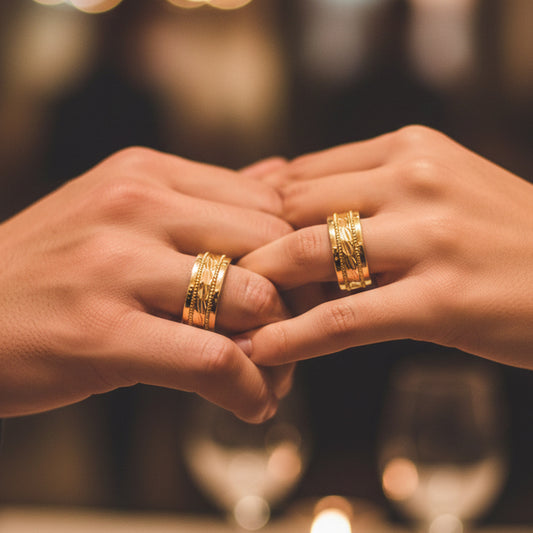 Manos de una pareja usando unas argollas en oro amarillo de 18 quilates de Joyería Caracas.