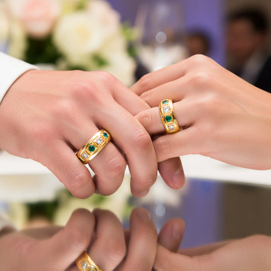 Manos de una pareja usando unas argollas en oro amarillo con cristales verdes y blancos de 18 quilates de Joyería Caracas. 