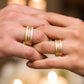 Manos de una pareja usando unas argollas en oro amarillo, blanco y rosa de 18 quilates de Joyería Caracas.