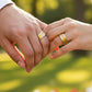 Manos de una pareja usando unas argollas de matrimonio en oro amarillo y blanco de 18 quilates de Joyería Caracas. 